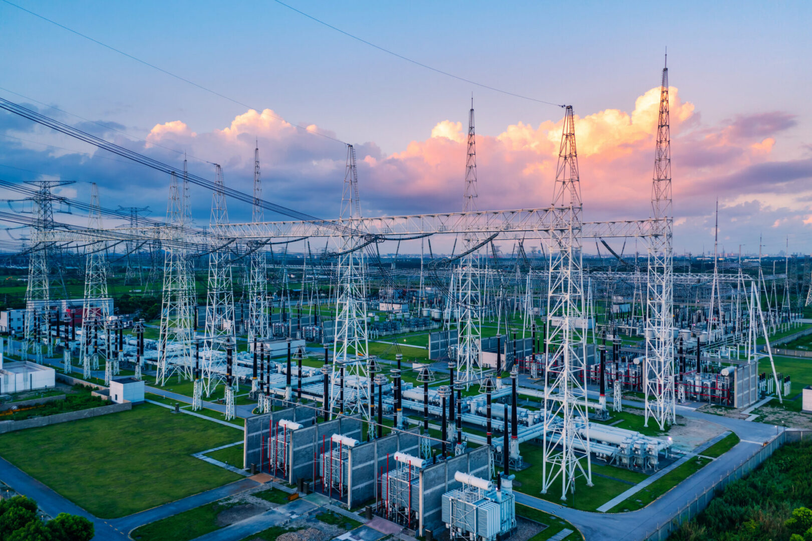 Electrical substation with towers at sunset.