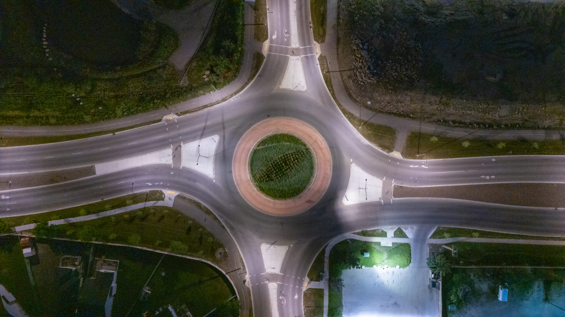 Aerial view of illuminated roundabout at night.